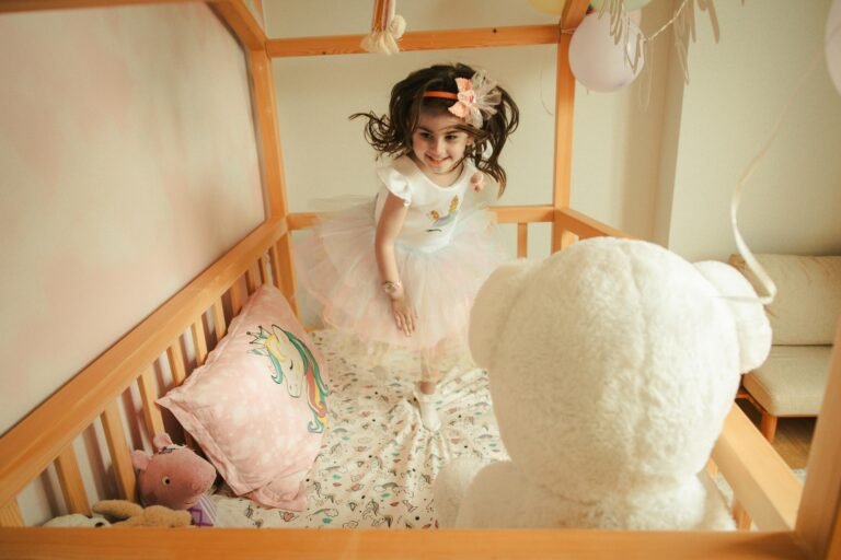 une-petite-fille-joue-sur-lit-sans-barreau-pour-bébé